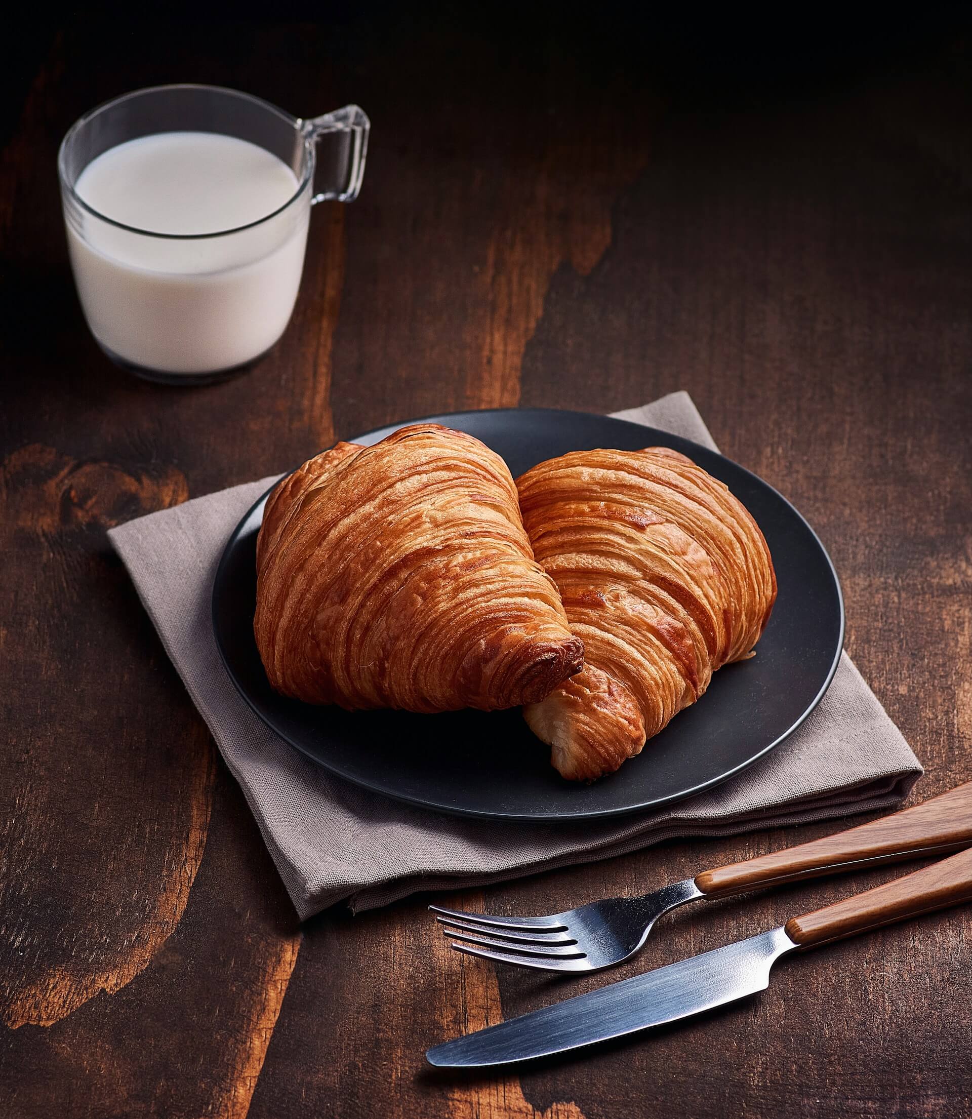 Croissants on a plate with a glass of milk